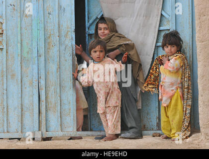 Les enfants afghans regarder les soldats du 2e Bataillon, 1e Régiment d'infanterie, 5e Brigade, 2e Division d'infanterie, effectuer une patrouille à pied à travers le village de Pir Zadeh, le 3 décembre 2009. Soldats américains mènent des opérations de contre-insurrection à l'appui de l'opération Enduring Freedom. Le s.. Mitchell de Dayton) Banque D'Images