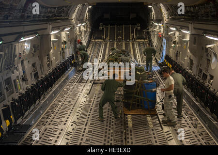 Le 535e Escadron de transport aérien C-17 Gloabmaster III arrimeurs et de techniciens, sécurisé et inspection du fret avant qu'un largage de at Joint Base Harbor-Hickam Pearl, Hawaï le 1 août la 535e offre des capacités de transport aérien et airdrop pour le théâtre du Pacifique. Le largage de matériel fait partie de la formation de routine de l'équipage et le personnel de la logistique. Le s.. Stephany Richards/ libéré) Banque D'Images