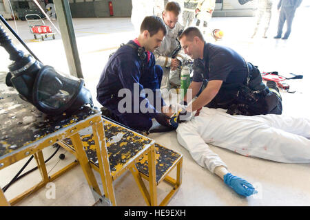 Les premiers intervenants du 436e Escadron de génie civile Service d'incendie, donner des soins à un membre de la victime simulée 1re classe Joshua Lamontagne, 436e Escadron de maintenance, le 18 octobre 2013 à Dover Air Force Base, Del. Lamontagne, un aéronef fossiles maintenance système, jouait le rôle de victime avec une blessure à la tête lors d'un exercice de sauvetage en espace confiné. Roland Balik) Banque D'Images