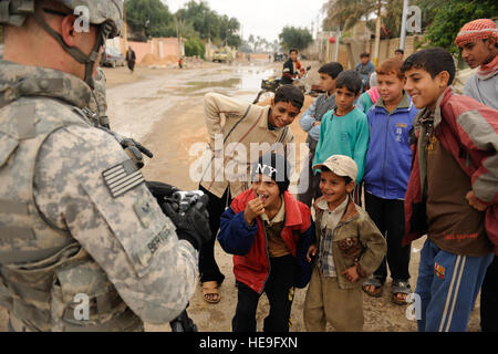 Les enfants iraquiens se rassemblent autour de U.S. Air Force Le s.. David Bertles, affecté au 1er escadron de la Caméra de combat, Charleston Air Force Base, L.C. (documents, comme il le cordon et de frapper les opérations en Iraq, Afak, le 30 novembre 2008. L'opération a été menée par des soldats américains de la 2e Bataillon, 8e Régiment d'infanterie, 2e Brigade Combat Team, 4e Division d'infanterie. Eric Harris Senior Airman Banque D'Images