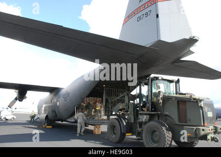 Garde, les réservistes en service actif et aviateurs charger des cargaisons sur une couronne de chêne C-130 Hercules Homestead Air Reserve Base, en Floride, à l'appui de l'opération réponse unifiée. Les palettes de fret sont de l'eau, de fournitures médicales et autres pour le transport aérien de la République dominicaine en faveur des victimes du tremblement de terre en Haïti. Le C-130 est affecté au 35ème escadron de transport aérien expéditionnaire situé près de San Juan, Puerto Rico. Banque D'Images