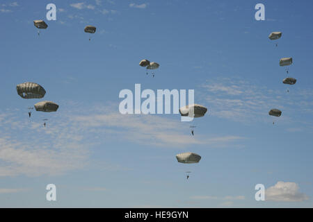 L'Armée américaine, la Marine et la Force aérienne saut de parachutistes C-130 Hercules du Français, Italien, Allemand, Néerlandais et des parachutistes canadiens près du village normand de Sainte-Mère-Église, France, 8 juin 2014. Près de 1 000 parachutistes ont participé à la messe d'airdrop dans le cadre du 70e anniversaire du débarquement en Normandie, France. Erica J. Knight. Banque D'Images