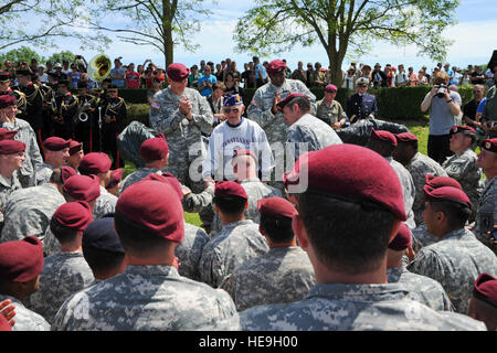 L'Armée américaine, le général John Nicholson Jr., gauche, général commandant, 82e Division aéroportée, écoute l'vétéran du jour Leslie Palmer Cruz parle de parachutistes de ses expériences au cours d'une cérémonie à la Iron Mike paratrooper memorial près du village normand de Sainte-Mère-Église, France, 8 juin 2014. Près de 1 000 parachutistes ont participé à la messe d'airdrop dans le cadre du 70e anniversaire du débarquement en Normandie, France. Erica J. Knight Banque D'Images