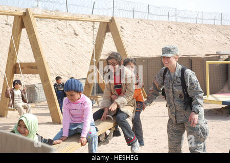 Navigant de première classe Sarah Coble, 886e Escadron des Forces de sécurité de la Force expéditionnaire du Canada, joue avec les enfants qui sont en visite dans la famille et les amis détenus dans le théâtre d'internement au camp Bucca, l'Iraq, le 10 février 2008. Aviateurs déployés à la 886e SESF exploitent les TIF's programme de visites vigoureux qui abrite les détenus déterminés à être une menace pour la sécurité contre les citoyens irakiens ou les forces de la coalition. Plus de 1 700 amis et membres de la famille visiter les détenus chaque semaine. Airman Coble est déployé à partir de la Base Aérienne de Keesler, au Mississippi (États-Unis Air Force Photo/Capt. Jason McCree) Banque D'Images