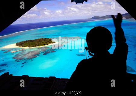 Le sergent de l'US Air Force. Khamonel Keo vagues pour les habitants qu'il va à l'arrière d'un C-130 Hercules sur la baie de Tumon, Guam lors de l'exercice Faire face au nord, 23 février 2011. L'US Air Force et de l'Air Force d'autodéfense japonaise conduite Faire face au nord chaque année à Andersen Air Force Base, Guam pour accroître la préparation au combat et l'interopérabilité en se concentrant sur la coordination et l'évaluation d'air tactiques, techniques et procédures. SSgt est Khamonel C-130 Hercules de l'arrimeur, 36e Escadron de transport aérien à Yokota Air Base, le Japon. Le s.. Angelita M. Lawrence Banque D'Images