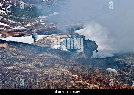 JOINT BASE ELMENDORF-RICHARDSON, Alaska - soldats de la compagnie Comanche, 1er Bataillon, 501e Régiment d'infanterie (Airborne), font leur chemin à travers la fumée au cours d'un assaut aérien le 12 mai. Les soldats ont pris part à la formation d'assaut aérien où les hélicoptères UH-60 Black Hawk en a une section de la plage et de l'Alaska Chugach ils ont été chargés d'engager une force opposée. Airman Senior Christopher brut) Banque D'Images