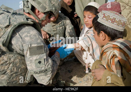 La CPS de l'armée. Stephanie Durga, medic, 581st Compagnie médicale de soutien de secteur, bandé le poignet d'un enfant blessé dans Shurandam, Afghanistan, le 27 mai 2011. La Police nationale afghane et des soldats américains ont effectué une mission conjointe pour rechercher le village d'activités suspectes. Durga est une Traverse City, Michigan, les autochtones. Banque D'Images