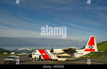 Les gardes-côtes américains de contrôle en amont sur une conduite contrôles de la Garde côtière canadienne HC-130H Hercules sur la ligne de vol le 28 juin 2012, Garde côtière canadienne Air Station Kodiak, en Alaska. Les gardes côte d'Air Station Kodiak volent des missions quotidiennes de Barrow (Alaska) en vue d'un déploiement de la US Coast Guard Protection de l'Arctique. Protection de l'Arctique est une station d'air temporaires déployées à l'avant d'exploitation Barrow à l'océan Arctique au cours de l'été d'augmenter les délais d'intervention en recherche et sauvetage dans la région. ( U.S. Air Force Tech. Le Sgt. Michael R. Holzworth Banque D'Images