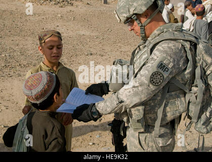 Le sergent de l'armée. 1re classe Stephen Anderson, agent de recouvrement, la Compagnie de la Police militaire 1775th, examine un enfant dans Shurandam devoirs du Village, l'Afghanistan, le 27 mai. La Police nationale afghane et des soldats américains ont effectué une mission conjointe pour rechercher le village pour les activités suspectes et rencontrer les anciens du village. Anderson est un carcajou Lake, Michigan, déployés à partir du Michigan Army National Guard. Banque D'Images