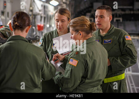 Air Force Reserve Maj. Shana Weber (centre), une infirmière de vol avec le 746e Escadron d'évacuation aéromédicale ici at Joint Base Lewis-McChord, et les membres de son examen par l'équipe d'un scénario de formation sur un domaine McChord C-17 Globemaster III au cours de l'avion de transport en vol de l'unité de formation médicale, le 21 janvier 2015. Les 2 100 hommes et femmes affectés à l'aide AW 746e l'Air Mobility Command (AMC) mission à travers le monde sur une base quotidienne, l'exécution de 44 pour cent de toutes les missions laissant JBLM C-17. (U.S. Air Force Reserve Jake Chappelle) Banque D'Images