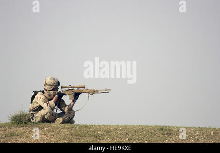 L'Armée US (USA) Spécialiste quatrième classe (SFC) Theodore Amell, 2e Peloton (PLT), Bravo (B) Société (CO), le 1er Bataillon (NE), 5e d'infanterie (INF), 25e Division d'infanterie (ID) (Stryker Brigade Combat Team (SBCT)), analyse l'horizon avec un système d'arme de sniper M21 pour des menaces lors d'une patrouille près de Mossoul, en Irak. Les SBCT est assigné à la force la liberté soutien à l'opération IRAQI FREEDOM. Le M21 est composé d'un 7,62 mm M14 fusil à la main et spécialement sélectionnés et des pièces d'une étendue. Banque D'Images