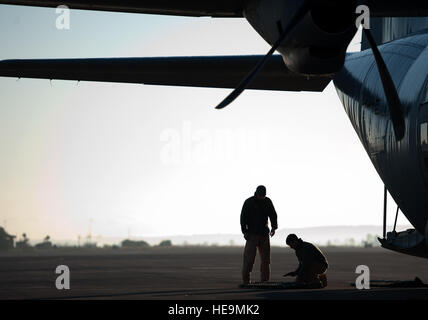 Navigant de première classe Andrew Bracamontes (à gauche) et l'Aviateur Senior Matthew Howard (à droite), Ramstein Envolez-vous membres de l'équipe de sécurité, affectés à la base aérienne de Ramstein, en Allemagne, de vérifier l'équipement avant d'embarquer à bord d'un C-130J Super Hercules, le 18 décembre à Sigonella Naval Air Station, en Italie. Les membres rapide a assuré la sécurité pour les aviateurs du 37e Escadron de transport aérien lors d'une mission en République centrafricaine, d'Afrique, la livraison des fournitures indispensables et du personnel dans le cadre d'une mission de maintien de la paix apportent soutien à la population civile perturbée par l'nationÕs conflits récents. Damon Ka Senior Airman Banque D'Images