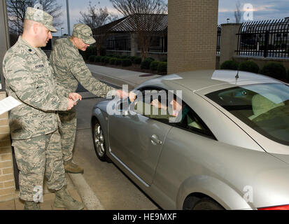 Le lieutenant-colonel Steven Sylvester, 436e Airlift Wing chef de la sécurité, de gauche, et le lieutenant-colonel Derek Salmi, 436e Escadron de soutien aux opérations, commandant de la deuxième de gauche, vérifier les cartes d'identité et passer des points de sécurité aux conducteurs lorsqu'ils entrent dans la base le 25 novembre 2014, à l'entrée principale sur Dover Air Force Base, Del. Sylvester et Salmi a rappelé aux conducteurs et aux passagers d'être en sécurité au cours de l'action de grâces Jour maison de vacances dans le cadre de la sécurité de l'aile Envoyer Off. Roland Balik) Banque D'Images