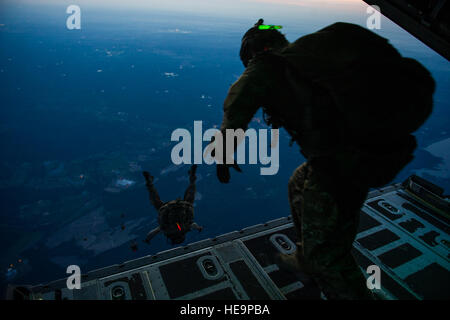 Les aviateurs américains avec la 22e Escadron tactique d'effectuer une faible à haute altitude à partir d'un saut d'ouverture J EC-130e Commando Solo aéronefs affectés à la 193e Escadron d'opérations spéciales, New York Air National Guard dans le ciel de Floride le 7 mai 2014, au cours d'Emerald Warrior 14. Emerald Warrior est un U.S. Special Operations Command-parrainé deux semaines/mixte exercice tactique combiné conçu pour fournir un entraînement militaire réaliste dans un milieu urbain. Le s.. Marleah Miller Banque D'Images