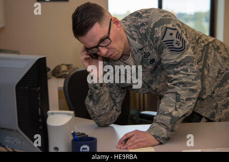 Le sergent-chef de l'Armée de l'air. Danny Damons, 673e contrôleur et le personnel de l'Escadre première agence sergent, parle à un particulier qui demande un congé d'urgence durant une conversation téléphonique at Joint Base Elmendorf-Richardson, Alaska, le 16 septembre 2015. Damons est responsable pour le moral, le bien-être, et la conduite des aviateurs qui appartiennent dans leur escadron et sont également des conseillers. Le s.. Sheila deVera) Banque D'Images