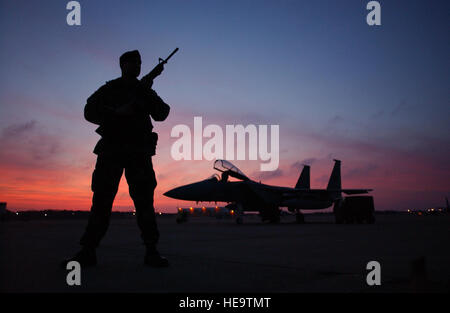 CAPE Cod, Massachusetts -- Le s.. Nassim Rizvi guards un F-15 Eagle sur la piste pendant un hiver chaud coucher de soleil ici le 23 décembre. Plusieurs membres de la 102e Escadre de chasse sont activés à l'appui de l'opération Noble Eagle. Le sergent Rizvi est affecté à la 102e Escadre de chasse des Forces de sécurité. Tech. Le Sgt. Sandra Niedzwiecki) Banque D'Images