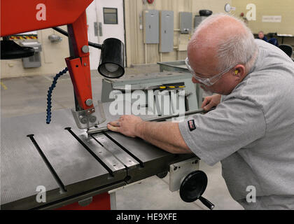 Greg Crosswhite, une maintenance 97e direction A-Team vol fabrication de structures métalliques, coupe l'excédent de métal mécanicien sur un tuyau qui servira de ligne hydraulique de remplacement pour l'US Air Force un KC-135 Stratotanker ravitaillement en vol, le 19 février, 2015. Fabrication a beaucoup de différents matériaux en main ; sheet metal, rivets, collage de produits chimiques, le Kevlar et le graphite. Un processus d'inspection de la qualité est effectué lorsque l'élément est prêt à ré-installer sur l'aéronef, ainsi qu'une fois l'installation terminée. Navigant de première classe Megan E. ACS Banque D'Images