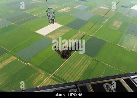 Un soldat allemand parachutes à partir d'un C-130J Hercules sur la zone de dépôt dans le sud-ouest de Alzey Allemagne le 15 juin 2010. Les soldats, aviateurs et marins, ainsi que des soldats de la Belgique, l'Allemagne, la Hongrie, la Grande-Bretagne, la Norvège et les Pays-Bas, ont participé à des opérations aéroportées durant la Semaine internationale 2010 de saut. L'US Air Force de réserve du 435ème Groupe d'intervention de l'organisation de la journée d'instaurer la confiance et les relations entre les alliés de l'OTAN. Le s.. Shawn Weismiller Banque D'Images