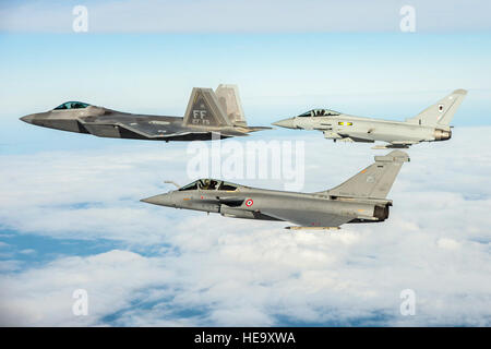 Un U.S. Air Force F-22 Raptor, British Royal Air Force Typhoon et Rafale de l'armée de l'air volent en formation dans le cadre d'un exercice trilatéral tenue à Langley Air Force Base, en Virginie, le 7 décembre 2015. L'exercice simule un dégradé très contestée, et opérationnellement-environnement limité, où les partenaires et les équipes au sol et les pilotes peuvent tester leur préparation. Kayla Newman Senior Airman) Banque D'Images