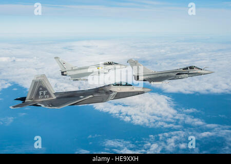 Un U.S. Air Force F-22 Raptor, British Royal Air Force Typhoon et Rafale de l'armée de l'air volent en formation dans le cadre d'un exercice trilatéral tenue à Langley Air Force Base, en Virginie, le 7 décembre 2015. L'exercice simule un dégradé très contestée, et opérationnellement-environnement limité, où les partenaires et les équipes au sol et les pilotes peuvent tester leur préparation. Kayla Newman Senior Airman) Banque D'Images