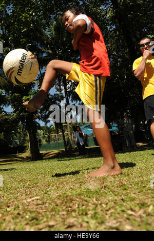 Un garçon passe le futbol futbol jeunesse lors d'un clinic 20 avril 2012, au camp Aguinaldo, Philippines. Les membres de l'équipe de football nationale des Philippines, l'Azkals, ainsi que des membres des services américains qui participent à l'exercice Balikatan 2012, donné de leur temps pour aider à la clinique jeunesse. Les participants ont été sélectionnés au moyen d'un programme de sensibilisation de l'église locale. Balikatan est une république des Philippines et des États-Unis portant sur l'exercice militaire de la formation sur le terrain, l'aide humanitaire et un exercice de poste de commandement. Banque D'Images