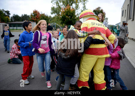 Les enfants de membres des services de pointe le chien Sparky hug incendie à la base aérienne de Spangdahlem, en Allemagne, le 9 octobre 2013, durant la Semaine de prévention des incendies. Kyle Gese Navigant de première classe Banque D'Images