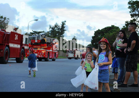 L'enfant regarde comme aviateurs américains avec le 18e Escadron de génie civil dur un assortiment de véhicules de lutte contre les incendies dans la rue pendant la Parade de la Semaine de prévention des incendies à Kadena Air Base, le Japon, le 9 octobre 2013. Navigant de première classe Keith James Banque D'Images