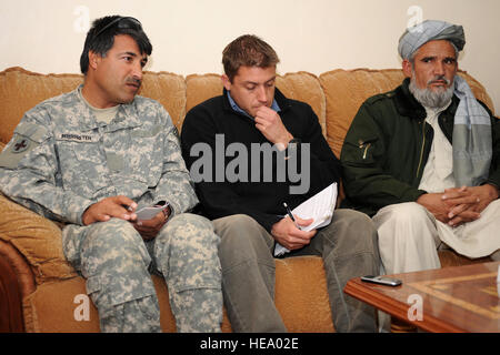 Grâce à l'aide d'un interprète afghan pour la Farah Équipe provinciale de reconstruction (EPR), Trevor Hublin, membre de l'Agence des États-Unis pour le développement international (USAID) (photo au centre) s'assoit à côté de Khan Abdul Satar, le nouveau député de la Farah Conseil provincial, au cours d'une réunion du Comité provincial de gestion des catastrophes, le 7 février 2010. Le comité se réunira en tant qu'une réponse à une inondation dans Por Chaman District qui a tué six femmes et six enfants, 60 chevaux, et 2 000 moutons. Après trois jours de fortes chutes de neige suivie de pluie, environ 200 jeribs (environ Banque D'Images