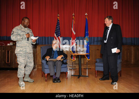 U.S. Air Force capitaine principal Sgt. Cornelius Thompson, à gauche, 100e Escadron de soutien des opérations, gestionnaire de l'aérodrome à la retraite présente le Commodore de la Royal Air Force, Charles Clarke, droite, un ancien prisonnier de guerre, avec un cadeau pendant le prisonnier de guerre/Missing in action déjeuner du souvenir, 18 Septembre, 2013, dans la galaxie Club sur RAF Mildenhall, Angleterre. Clarke et Andrew sages, les deux prisonniers pendant la Seconde Guerre mondiale, a parlé de leurs expériences en tant que membres de l'équipe de prisonniers de Mildenhall. Navigant de première classe Preston Webb Banque D'Images