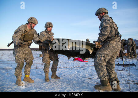 Parachutistes affecté à une batterie, 2e Bataillon de parachutistes, 377e Régiment d'artillerie, d'infanterie 4e Brigade Combat Team (Airborne), 25e Division d'infanterie de l'armée américaine, l'Alaska, se préparer pour placer une plaque de base d'artillerie aéroportée lors des exercices de tir réel et joint Base Elmendorf-Richardson, Alaska, 22 novembre 2016. Après une forte chute de l'équipement et d'aérolargage, les parachutistes perfectionné leurs compétences par la mise en place et le tir d'un obusier de 105 mm. Les soldats de 4/25 IBCT appartiennent à la seule brigade aéroportée américaine dans le Pacifique et sont formés pour exécuter les manœuvres dans Banque D'Images