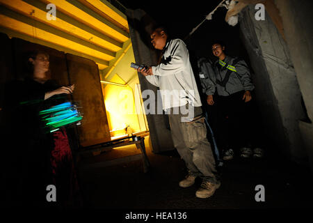 Le capitaine Dori Mansur dirige un groupe de victimes dans une maison hantée à Joint Base Balad, l'Iraq, le 1 novembre 2008. Des volontaires de l'Armée de l'air et de l'armée mis en place à l'intérieur de la maison hantée Holt, stade d'effrayer les membres du service et les entrepreneurs de l'Halloween et la nuit après. Mansur, un déploiement d'installation avec l'agent de préparation logistique expéditionnaire 332e Escadron, est déployée à partir de McGuire Air Force Base, au New Jersey. Banque D'Images