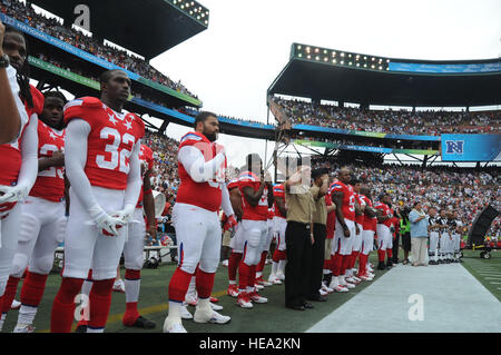 HONOLULU, Hawaii - Deux marins affectés à saluer américaines du Pacifique, en collaboration avec les membres de l'American Football Conference pendant l'hymne national avant le début de la 2011 Pro Bowl à l'Aloha Stadium d'Honolulu, Hawaï le 30 janvier. C'est la 31e fois que l'événement a eu lieu à New York, où il a été détenu pendant 30 ans tout droit jusqu'à l'année dernière quand il a eu lieu à Miami, en Floride, dans un effort pour renouveler l'intérêt pour le jeu. Cette décision a été accueillie avec beaucoup de débats et de critiques par les fans et les joueurs et le jeu a été ramené à New York cette année. Hawaï est la maison à beaucoup de militaires américains et les Banque D'Images