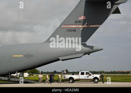 Florida Advanced Surgical et le transport d'une équipe de membres de l'US Air Force avec le 32e Escadron de port aérien, l'Aéroport International de Pittsburgh, la Réserve aérienne Township, en Pennsylvanie, et le 67e Escadron Port Aérien Hill Air Force Base, dans l'Utah., préparer pour charger un camion Ford 450 full size sur à un C-17 Globemaster III de cargo à la Coast Guard Air Station Miami, Opa-locka, Floride, le 26 juillet 2013. Personnels civils et militaires travaillent ensemble à l'appui de l'exercice guerrier 86-13-01 (WAREX)/exercice Global Medic, 2013. WAREX unités fournit une occasion de répéter des manœuvres militaires et tactiques Banque D'Images