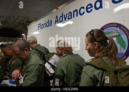 Les membres de la Floride et de l'équipe chirurgicale avancée Transports, bord d'un C-17 Globemaster III de cargo Coast Guard Station à l'Air de Miami, Opa-locka, Floride, le 26 juillet 2013. Personnels civils et militaires travaillent ensemble au cours de l'exercice guerrier 86-13-01 (WAREX)/exercice Global Medic, 2013,. WAREX unités fournit une occasion de répéter des manœuvres militaires et tactiques. Tenu conjointement avec WAREX, Global Medic est un rapport annuel conjoint-terrain conçu pour reproduire tous les aspects du théâtre combattre soutien médical.' Tech. Le Sgt. Efren Lopez Banque D'Images