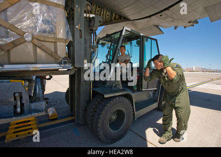 Les hauts de la Garde nationale américaine aviateur (SRA) John Turner, droite, C-130H Hercules l'arrimeur du 192e Escadron de transport aérien, de la base de la Garde nationale aérienne du Nevada Reno, guides U.S. Air Force SrA Marieto Tabajonda, une antenne porter à partir de la 56e escadre aérienne, Port Mars Air Reserve Base, en Californie, qu'ils travaillent ensemble pour charger une palette de l'offre médicale sur un C-130H à l'Aéroport International de Reno, le 13 juin 2012 au cours de 2012 Global Medic. Global Medic est un exercice annuel de formation conjointe sur le terrain pour le théâtre et la masse des systèmes d'évacuation aéromédicale composants médicaux conçus pour reproduire tous les aspects Banque D'Images