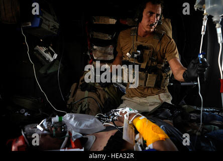 Airman Senior Landwerlen de Noé, pararescueman avec le 129e Escadron de sauvetage expéditionnaire, s'occupe d'un blessé un soldat de l'armée nationale afghane, Hemland, province de l'Afghanistan. Landwerlen fournira des soins à la soldat blessé jusqu'à ce qu'ils peuvent lui fournir en toute sécurité à l'hôpital. Banque D'Images