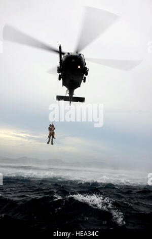 Un pararescoureur du 320e escadron de tactiques spéciales effectue un sauvetage en eau en hissant un membre de l'équipe Gold dans un HH-60 du 33e escadron de sauvetage pendant le Thunder d'or 2,0 au Camp Hansen, un exercice d'entraînement d'aide humanitaire et de secours en cas de catastrophe. Banque D'Images
