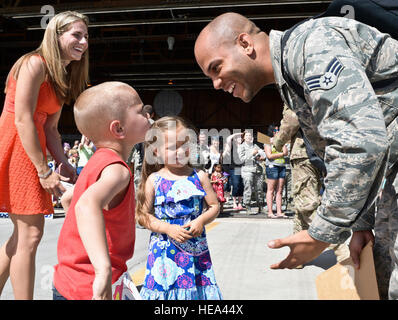Decoltius Senior Airman Dickerson, 726ème escadron de contrôle de l'air, les retours d'un déploiement de sa femme et de ses enfants lors d'une célébration à la Mountain Home Air Force Base flightline, le 23 mai 2014, à la base dans le sud-ouest de l'Idaho. Après un baiser bonjour à sa fille, le fils de Dickerson demande quand ils vont à Disney Land, qui a abouti à une situation émotionnelle, et d'un retour mémorable pour la famille Dickerson. 'Hardrock' aviateurs fourni critiques temps de commandement et de contrôle de gestion de la bataille à l'aide de capteurs et de communication situé à l'ensemble de l'Afghanistan. Le sergent-chef. Kevin Wallace Banque D'Images