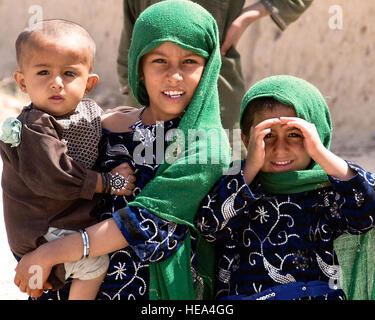 Deux petites filles regarder comme une unité de la Police nationale afghane et des Marines du 2e Bataillon, 2e patrouille marine, en dehors de la base d'opération avancée Delhi, District de Garmsir, province de Helmand, le 15 mars. Les Marines du 2e bataillon sont intégrés les mentors, vivant et travaillant aux côtés de la police nationale afghane. Banque D'Images