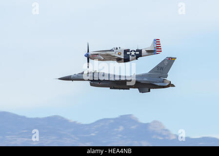 Un P-51 Mustang, haut, et un F-16D Fighting Falcon, bas, effectuer une manœuvre aérienne au cours de l'Entraînement en vol et du patrimoine 2016 Certification Course à la base aérienne Davis-Monthan Air Force Base, en Arizona, le 6 mars 2016. Créé en 1997, le CCCPP certifie pilotes civils de la ville historique de l'aviation militaire et les pilotes de l'US Air Force pour voler en formation ensemble au cours de la prochaine saison de démonstrations aériennes. Airman principal Chris Massey Banque D'Images