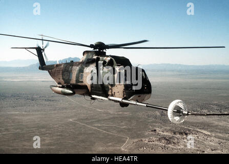 Un avion vue côté droit d'un HH-3E hélicoptère Jolly Green Giant être ravitaillé par un C-130 Hercules lors d'un exercice d'entraînement de guerre chimique. Banque D'Images