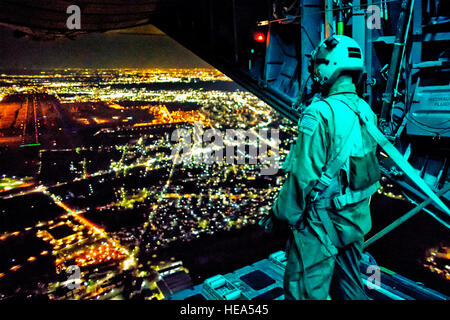 Le s.. Nickolas Alarcon, 36e Escadron de transport aérien l'arrimeur, observe une zone de chute de l'arrière d'un C-130 Hercules après le déploiement d'une charge utile de la lumière au-dessus de Yokota Air Base, Japon, le 21 février 2013. Les équipages de C-130 ont démontré leurs capacités de transport aérien pendant une semaine de préparation. Yasuo Osakabe) Banque D'Images