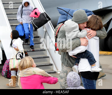 Airman Senior Jesse Hamblin, 22e Groupe de Maintenance Les opérations de maintenance center controller, il embrasse sa femme et ses enfants après le retour d'un déploiement le 20 janvier 2015, à McConnell Air Force Base, Kan. Près de 30 aviateurs sont rentrés chez eux d'un déploiement de différentes longueurs. Banque D'Images