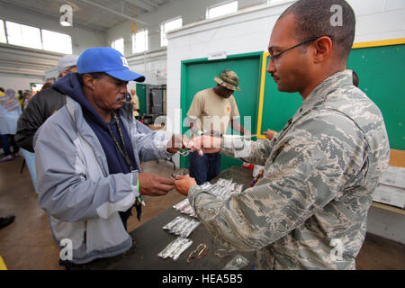 De la santé publique 1er lieutenant Gyasi J. Mann, droite, 108th Medical Group, New Jersey Air National Guard, aide les sans-abri d'un ancien combattant choisir une paire de lunettes de lecture en mode veille jusqu'à 2012 la National Guard Armory à Cherry Hill, le 28 septembre 2012. Le New Jersey Department de l'armée et des Affaires des anciens combattants ainsi que des soldats de la Garde nationale du New Jersey et les aviateurs et le socle de South Jersey Committee, Inc. co-organisé le stand jusqu'à fournir des anciens combattants sans abri avec l'accès aux soins de santé mentale, le dépistage, l'abus de counseling, services sociaux - des bons d'alimentation et le chômage, juridique Banque D'Images