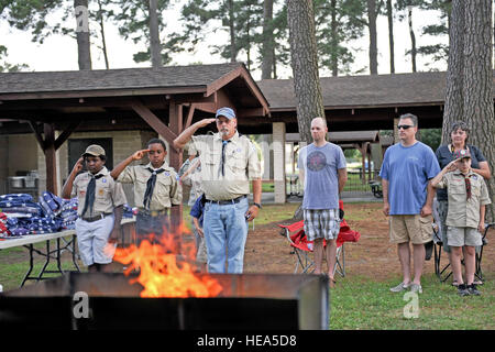 Les membres de l'équipe de Seymour un ancien drapeau de cérémonie salute comme taps joue le 14 juin 2014, à Seymour Johnson Air Force Base, la Caroline du Nord. Les Scouts locaux et 4e Escadre de chasse gardes d'honneur ont travaillé ensemble pour disposer de respectueusement plus de 100 drapeaux endommagé. Navigant de première classe Aaron J. Jenné) Banque D'Images