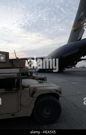 Huit véhicules blindés à roues polyvalents à haute mobilité sont montés pour être chargés dans un C-17 Globemaster III sur une base aérienne d'Asie du Sud-Ouest, illustrant la capacité de transport aérien rapide et l'utilisation de véhicules blindés M998 HMMWV renforcés pour le transport de troupes et de marchandises dans les zones opérationnelles. Banque D'Images