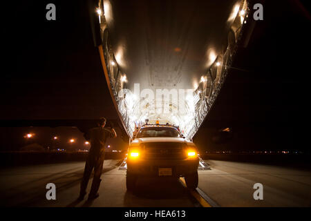 Les cadres supérieurs de l'US Air Force Airman Joshua Bischoff, arrimeur avec le 15e Escadron de transport aérien, charge un camion utilitaire sur un C-17 Globemaster III Mars Air Reserve Base, Californie, à être transporté à New York à l'appui des opérations de secours de l'Ouragan Sandy, le 1 novembre 2012. L'ouragan Sandy formé dans l'ouest de la mer des Caraïbes et affectées à la Jamaïque, Cuba, Haïti et les Bahamas avant qu'il est descendu au milieu de l'Atlantique des États-Unis. Le s.. Greg C. Biondo) Banque D'Images