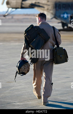 Un capitaine des Marines, un Gensicki Robert CH-53E Super Stallion pilote d'hélicoptère de la Marine à l'Escadron d'hélicoptères lourds, 462 aéronefs maritimes Groupe 16, 3rd Marine Aircraft Wing, Marine Corps Air Station Mira Mar, Californie, porte son équipement vers l'avion au cours de l'exercice 2-15 à la formation intégrée Marine Corps Air Ground Combat Center (MCAGCC) Twentynine Palms en Californie, le 11 février 2015. MCAGCC mène de tir réel pertinents interarmes, les opérations urbaines, et des articulations ou de la Coalition qui favorisent la formation d'intégration au niveau de l'état de préparation des forces opérationnelles. Le s.. Kyle Brasier Banque D'Images