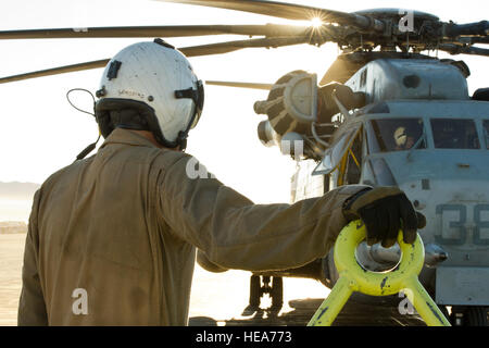 La Marine américaine lance le Cpl. Genscki Scott, un chef d'équipe affectée à l'Escadron 462 hélicoptères lourds Marine, Marine Aircraft Group 16, 3rd Marine Aircraft Wing, Marine Corps Air Station Mira Mar, Californie, attend que le démarrage du moteur de CH-53E Super Stallion hélicoptère pendant la formation intégrée à l'exercice 2-15 Marine Corps Air Ground Combat Center (MCAGCC) Twentynine Palms en Californie, le 11 février 2015. MCAGCC mène de tir réel pertinents interarmes, les opérations urbaines, et des articulations ou de la Coalition qui favorisent la formation d'intégration au niveau de l'état de préparation des forces opérationnelles. Le s.. Kyle Brasier Banque D'Images