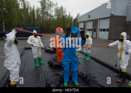 Airman Senior Matthieu Castellanos, bleu, et de la Garde nationale aérienne Air National Guard Le s.. James Mainolfi, orange, passer par simulation de la décontamination dans leurs combinaisons chimiques totalement intégré au cours de formation en intervention d'urgence sur la base de Joint Base Elmendorf-Richardson, Alaska, le 14 mai 2015. Castellanos est un 773d de l'Escadron du Génie Civil Génie de l'environnement bio-technicien et un natif de Wescovena, Californie Mainolfi est un 176e Groupe médical bio-ingénierie de l'environnement technicien et un natif de Rutland, Vermont. Tech. Le Sgt. Robert Barnett) Banque D'Images